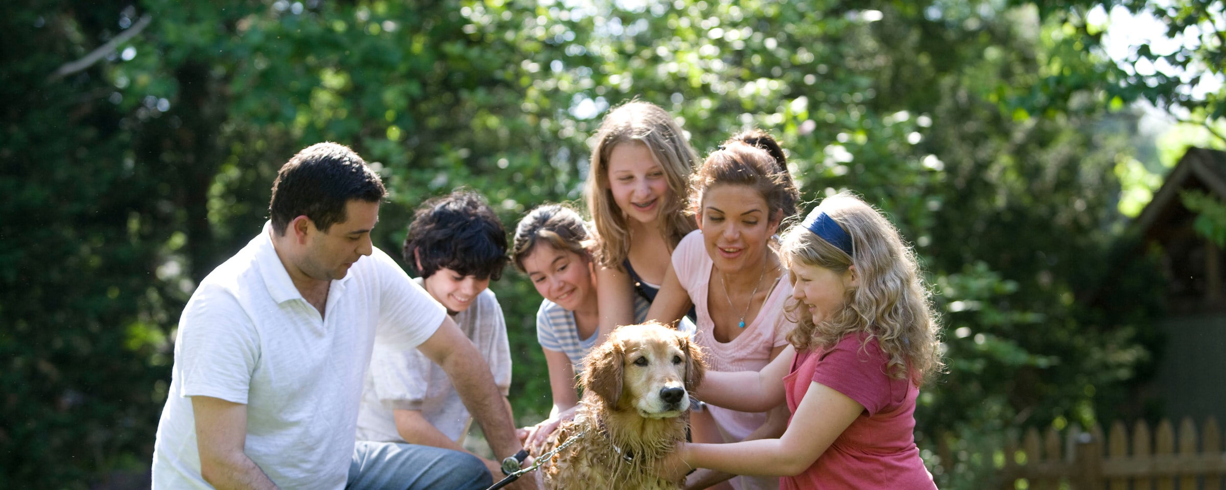 Family standing in a field with their dog