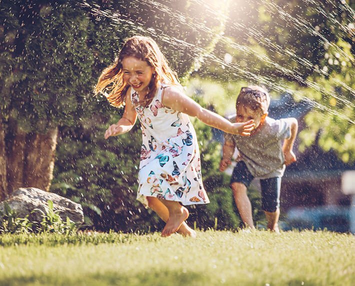 children playing in sprinklers