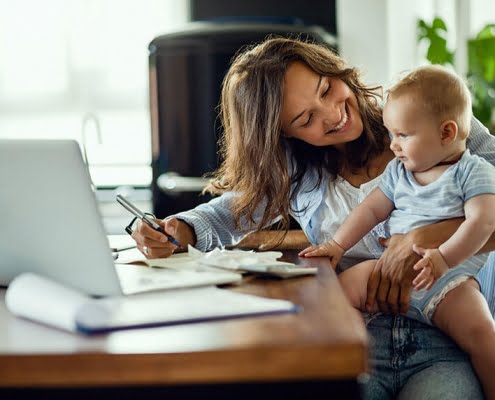 woman doing taxes with baby in lap