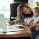 woman doing taxes with baby in lap